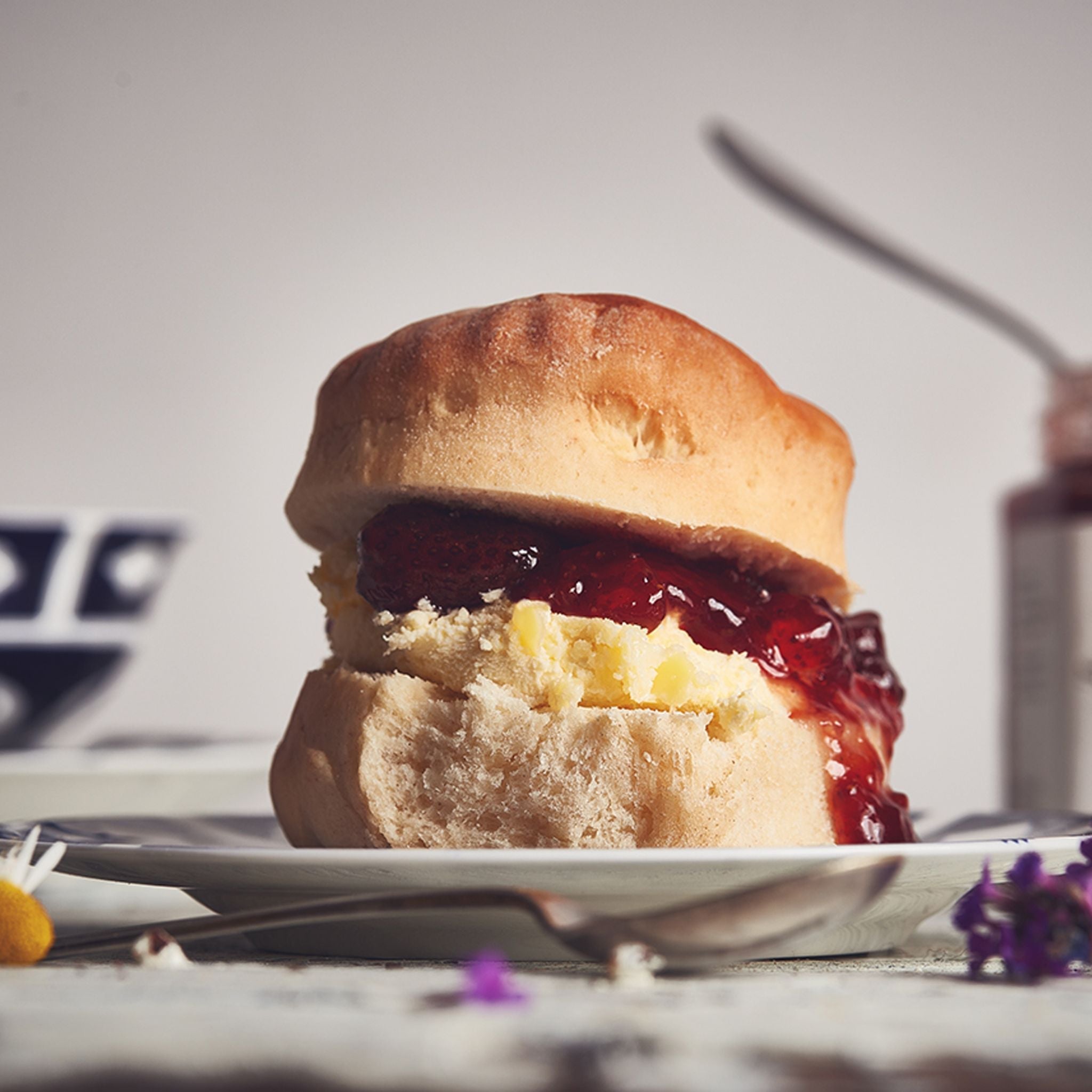 Full Scone with cream and jam on plate